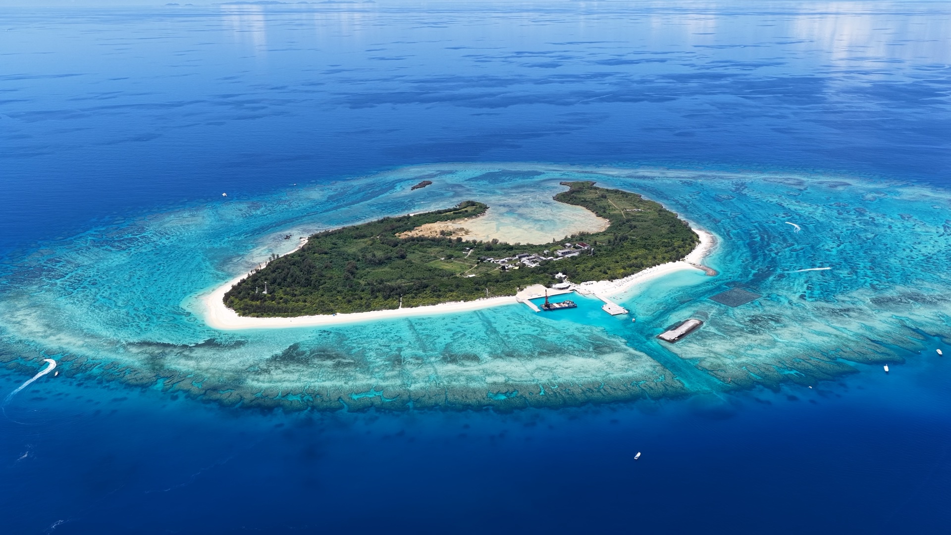 青い海とサンゴ礁に囲まれた水納島を上空から見た風景